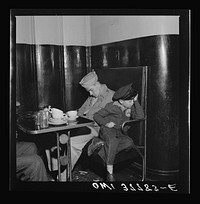 Louisville, Kentucky. Bus passengers sleeping in a booth in the lunchroom of the Greyhound bus terminal at 3 a.m., since all the benches were full. Sourced from the Library of Congress.