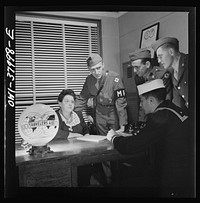 A Greyhound bus trip from Louisville, Kentucky, to Memphis, Tennessee, and the terminals. At travelers' aid desk in the bus terminal at Memphis, Tennessee. Servicemen ask for help in finding rooms, quickest route to get home, etc.. Sourced from the Library of Congress.