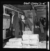 Bus trip from Knoxville, Tennessee to Washington, D.C. Girl baggage clerk loading newspapers onto a bus at Knoxville, Tennessee. These will be left at small towns along the way. Sourced from the Library of Congress.