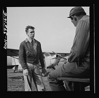 Frederick, Maryland. After a solo flight, Walter Spangenberg, a student at Woodrow Wilson High School, listens to a criticism from his instructor at Stevens Airport. Sourced from the Library of Congress.