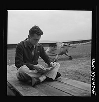 [Untitled photo, possibly related to: Frederick, Maryland. Walter Spangenberg, a student at Woodrow Wilson High School, studying his English lesson while waiting to fly at the Stevens Airport]. Sourced from the Library of Congress.
