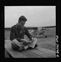 Frederick, Maryland. Walter Spangenberg, a student at Woodrow Wilson High School, studying his English lesson while waiting to fly at the Stevens Airport. Sourced from the Library of Congress.