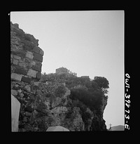 Castel Mola (vicinity). Castle on mountain peak over-looking Taormina and the sea. One of the peacetime tourist attractions visited by the British Eighth Army on a day off. Sicily. Sourced from the Library of Congress.