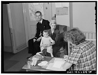 [Untitled photo, possibly related to: Washington, D.C. A naval officer and his wife leaving instructions for the care of their child whom they are leaving in the nursery of the United Nations service center while they wait between trains]. Sourced from the Library of Congress.