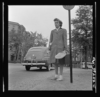 Washington, D.C. Sally Dessez, a student from Woodrow Wilson High School, waiting for a bus. From church, she went to the tennis court to play off a school match. Sourced from the Library of Congress.