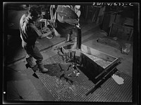Boeing aircraft plant, Seattle, Washington. Production of B-17 (Flying Fortress) bombing planes. Pouring a lead die to be used in the production of parts. Sourced from the Library of Congress.