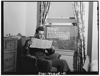 [Untitled photo, possibly related to: Washington, D.C. A lieutenant in the United States Army Air Transport Command reading the paper in his room at the United Nations service center]. Sourced from the Library of Congress.