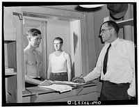 Washington, D.C. Servicemen getting towels and soap from an attendant in the enlisted men's shower room at the United Nations service center. Sourced from the Library of Congress.