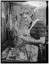 [Untitled photo, possibly related to: Washington, D.C. Lynn Massman, wife of a second class petty officer who is studying in Washington, preparing dinner]. Sourced from the Library of Congress.