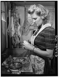 Washington, D.C. Lynn Massman, wife of a second class petty officer who is studying in Washington, preparing dinner. Sourced from the Library of Congress.