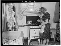 Washington, D.C. Lynn Massman, wife of a second class petty officer who is studying in Washington, cooking dinner. Sourced from the Library of Congress.