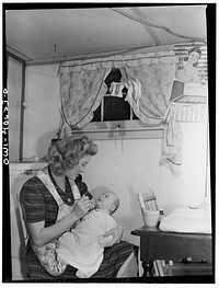 Washington, D.C. Lynn Massman, wife of a second class petty officer who is studying in Washington, D.C., feeding an eight weeks old son cereal. Sourced from the Library of Congress.