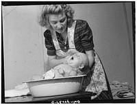 Washington, D.C. Lynn Massman, wife of a second class petty officer studying in Washington, D.C. giving eight weeks old Joey his daily bath. Sourced from the Library of Congress.