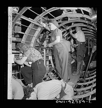 [Untitled photo, possibly related to: Boeing aircraft plant, Seattle, Washington. Production of B-17F (Flying Fortress) bombing planes. A crew working in a nearly completed fuselage section]. Sourced from the Library of Congress.