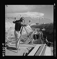 Columbia Steel Company at Geneva, Utah. Surveyor running lines for a water intake tunnel to serve a new steel mill under construction which will make important additions to the vast amount of steel needed for the war effort. Sourced from the Library of Congress.