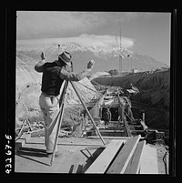 [Untitled photo, possibly related to: Columbia Steel Company at Geneva, Utah. Surveyor running lines for a water intake tunnel to serve a new steel mill under construction which will make important additions to the vast amount of steel needed for the war effort]. Sourced from the Library of Congress.