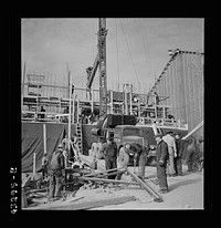 [Untitled photo, possibly related to: Columbia Steel Company at Geneva, Utah. Setting a pipe with a derrick during the construction of a new steel mill which will make important additions to the vast amount of steel needed for the war effort]. Sourced from the Library of Congress.