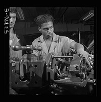 NYA (National Youth Administration) work center, Brooklyn, New York. Turret-lathe workers,  and white, who are receiving training in machine shop practice, carrying out an operation on a turret lathe. Sourced from the Library of Congress.