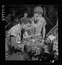 NYA (National Youth Administration) work center, Brooklyn, New York. Two turret-lathe workers,  and white, who are receiving training in machine shop practice, watching a cutting-off operation on a turret lathe. Sourced from the Library of Congress.