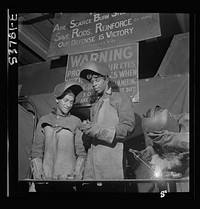 NYA (National Youth Administration) work center, Brooklyn, New York. Two welders, who are receiving training in machine shop practice, building up an undersize shaft by arc welding to be re-machined to size. Sourced from the Library of Congress.