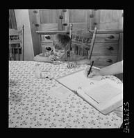 East Montpelier, Vermont. Richard, age five, son of the farmer Charles Ormsbee, has his own war project; he has agreed to lick all the savings stamps for the family. Sourced from the Library of Congress.