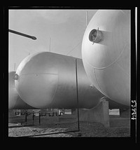 Las Vegas, Nevada. Like a row of dirigible balloons, the propane gas storage tanks rest upon the floor of the southern Nevada desert at Basic Magnesium's giant plant, where magnesium is produced. Sourced from the Library of Congress.
