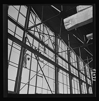 [Untitled photo, possibly related to: Las Vegas, Nevada. Painters at work seventy feet above ground on the gigantic construction of the Basic Magnesium Incorporated plant in the southern Nevada desert. A tower of another building and mountain tops can be seen in the background]. Sourced from the Library of Congress.