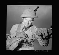 [Untitled photo, possibly related to: Fort Belvoir, Virginia. A soldier handling barbed wire with special gloves which are clasped instead of sewn together]. Sourced from the Library of Congress.