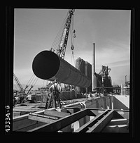 [Untitled photo, possibly related to: Columbia Steel Company at Geneva, Utah. Setting a pipe with a derrick during the construction of a new steel mill which will make important additions to the vast amount of steel needed for the war effort]. Sourced from the Library of Congress.
