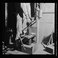 New Idria, California. Filling flasks of triple-distilled mercury at the New Idria Quicksilver Mining Company's mercury extraction plant. The flask contains seventy-six pounds of mercury. Sourced from the Library of Congress.