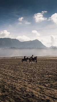 Nature mobile wallpaper background, horseback riding at Mount Bromo, Indonesia