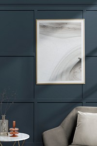 Picture frame with abstract art by a gray velvet armchair