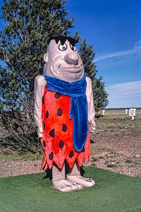 Fred Flintstone statue, Flintstone's Bedrock City, Rts. 64 and 180, Valle, Arizona (1987) photography in high resolution by John Margolies. Original from the Library of Congress. Digitally enhanced by rawpixel.