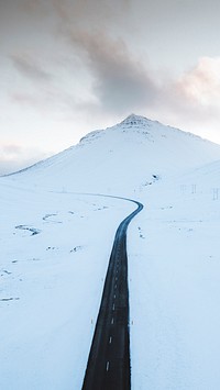 Nature phone wallpaper background, long black road on the white winter landscape