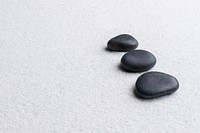 Black zen stones stacked on white background in wellness concept