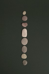 Zen stones stacked on green background in health and wellbeing concept