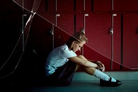 Depressed high school girl sitting by lockers in hallway with cracked glass effect