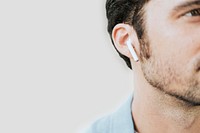 American man listening to music on wireless earphones closeup