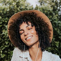 Woman wearing earphones in the garden remixed media