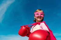 Superhero girl smiling on blue sky for education portrait