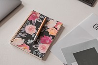 Aesthetic floral notebook and pen on a table