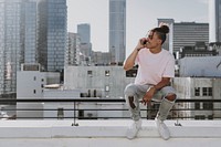 Cool man chatting on a phone at rooftop balcony