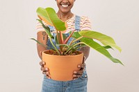 Happy woman holding a potted houseplant