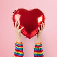 LGBTQ+ community heart balloon held by hands