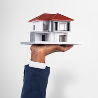 Hand holding house real estate and property model