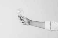 Hand holding a light bulb, black and white photo