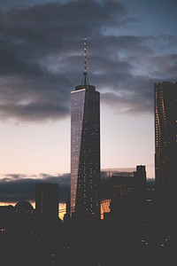 A dim shot of a skyscraper with a long spire in New York on an evening. Original public domain image from Wikimedia Commons