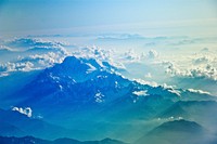 Bird&#39;s-eye view on a snow-capped mountain range with clouds obscuring the horizon. Original public domain image from <a href="https://commons.wikimedia.org/wiki/File:Icy_blue_mountain_range_(Unsplash).jpg" target="_blank">Wikimedia Commons</a>