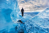 A person standing on frozen water in Jökulsárlón. Original public domain image from <a href="https://commons.wikimedia.org/wiki/File:Ice_Land_(Unsplash).jpg" target="_blank" rel="noopener noreferrer nofollow">Wikimedia Commons</a>