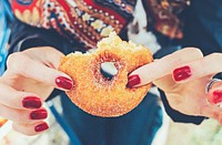 Hands with painted nails holding a bitten sugary donut. Original public domain image from <a href="https://commons.wikimedia.org/wiki/File:Bite_of_a_Doughnut_(Unsplash).jpg" target="_blank" rel="noopener noreferrer nofollow">Wikimedia Commons</a>